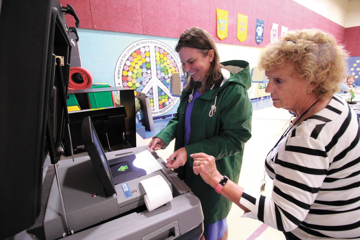 a vote for fox: Cranston native and former Herald editor, Joy Fox, who ran for the Democratic nomination for the Second Congressional District. Now a resident in Warwick , she  was voter 137.  “I’m feeling lucky with that number,” she said. Assisting her is poll worker Janice Costello.